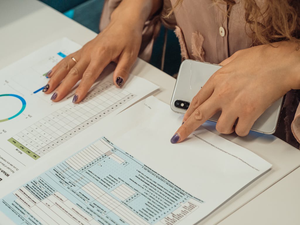 Close-up of a woman reviewing financial documents with graphs on a desk.